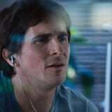 Christian Bale looks at a computer screen.