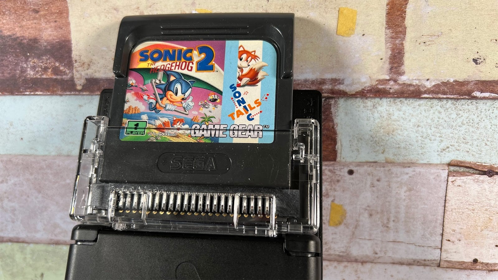 Game Gear cartridges pop up past the top of the unit while inserted.