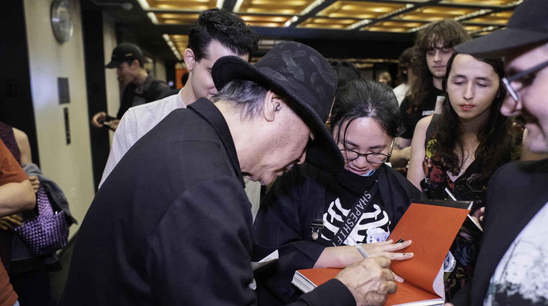 Amano focuses on an autograph.