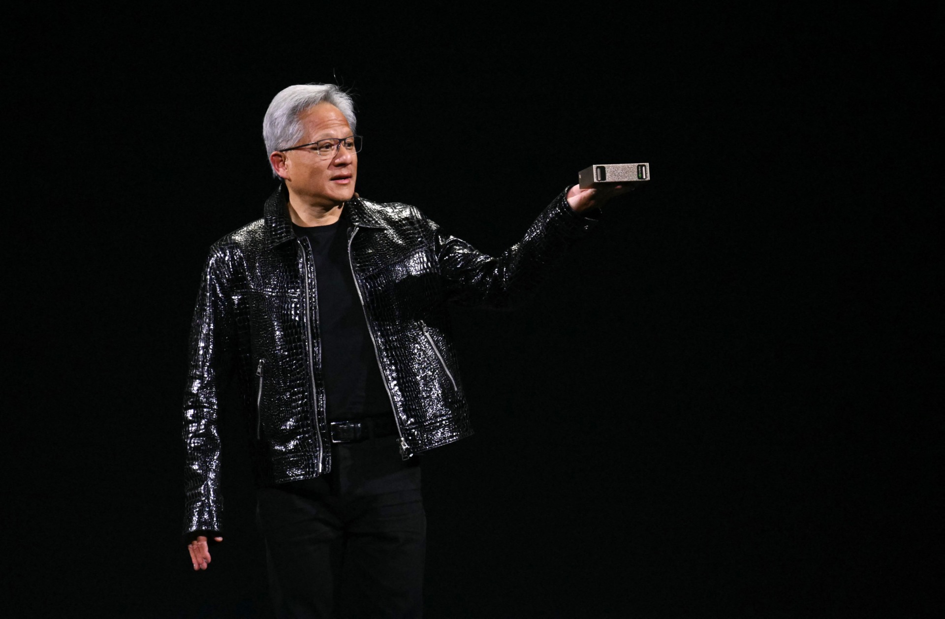 Nvidia CEO Jensen Huang holds a personal AI supercomputer during his keynote at the Consumer Electronics Show (CES) in Las Vegas, Nevada on January 6, 2025.