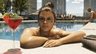 A woman sits in a pool with her martini.