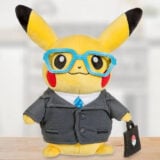 An Intern Pikachu plush wears a suit, glasses, and holds a briefcase.