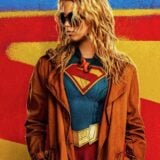 Supergirl appears in front of a big S.