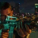 A man holds up a rifle in a city.