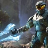 Master Chief holds an energy weapon.