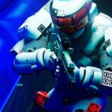 A runner hold up a weapon in a blue hallway.