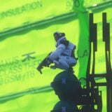 A thief stands watch over a green fluorescent background.