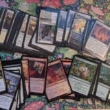 A photo of various assorted Secrets of Strixhaven Magic cards scattered on a mat.