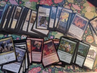 A photo of various assorted Secrets of Strixhaven Magic cards scattered on a mat.