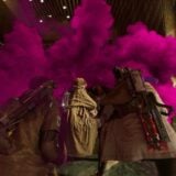 Thieves run into purple smoke in a skyscraper.