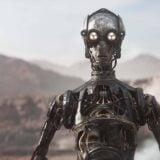 A droid appears in a desert.