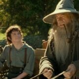 Gandalf and Frodo ride in a cart.