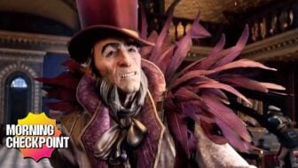 A weird-looking man wears feathers.