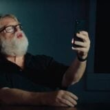 Gabe Newell looks at his phone.