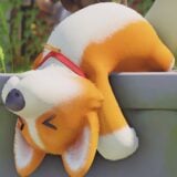 A stuffed dog falls over a wall.
