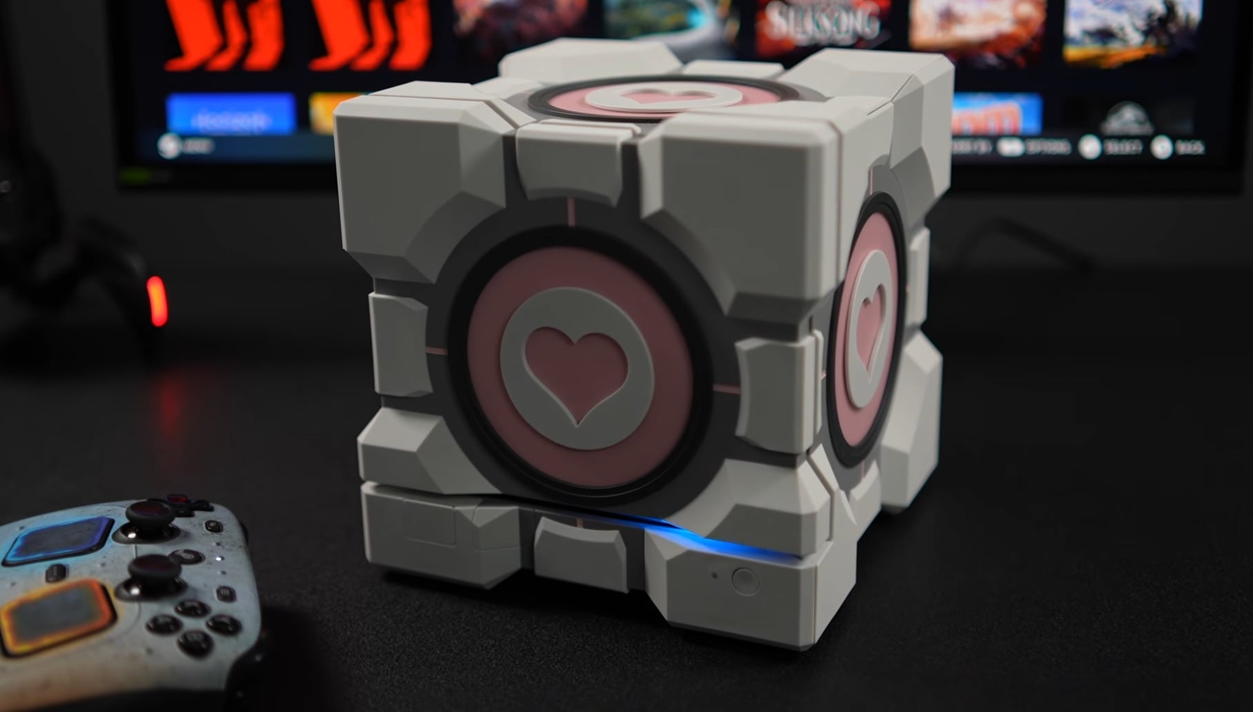 A Companion Cube sits on a desk.