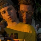 A man holds a gun and another person.