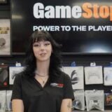 A woman stands behind the counter at GameStop.