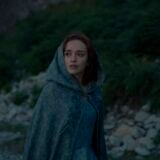 Olivia Cooke in House of The Dragon wearing a cloak looking apprehensively