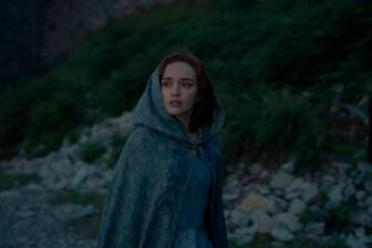 Olivia Cooke in House of The Dragon wearing a cloak looking apprehensively