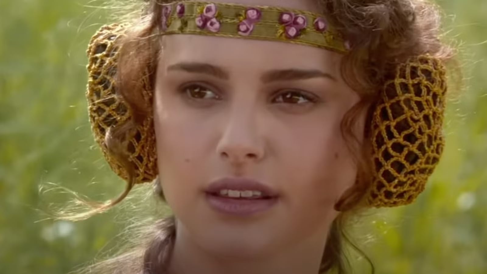 Padme looks confused in a grassy field.