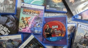 PlayStation game discs and boxes sit on a floor.