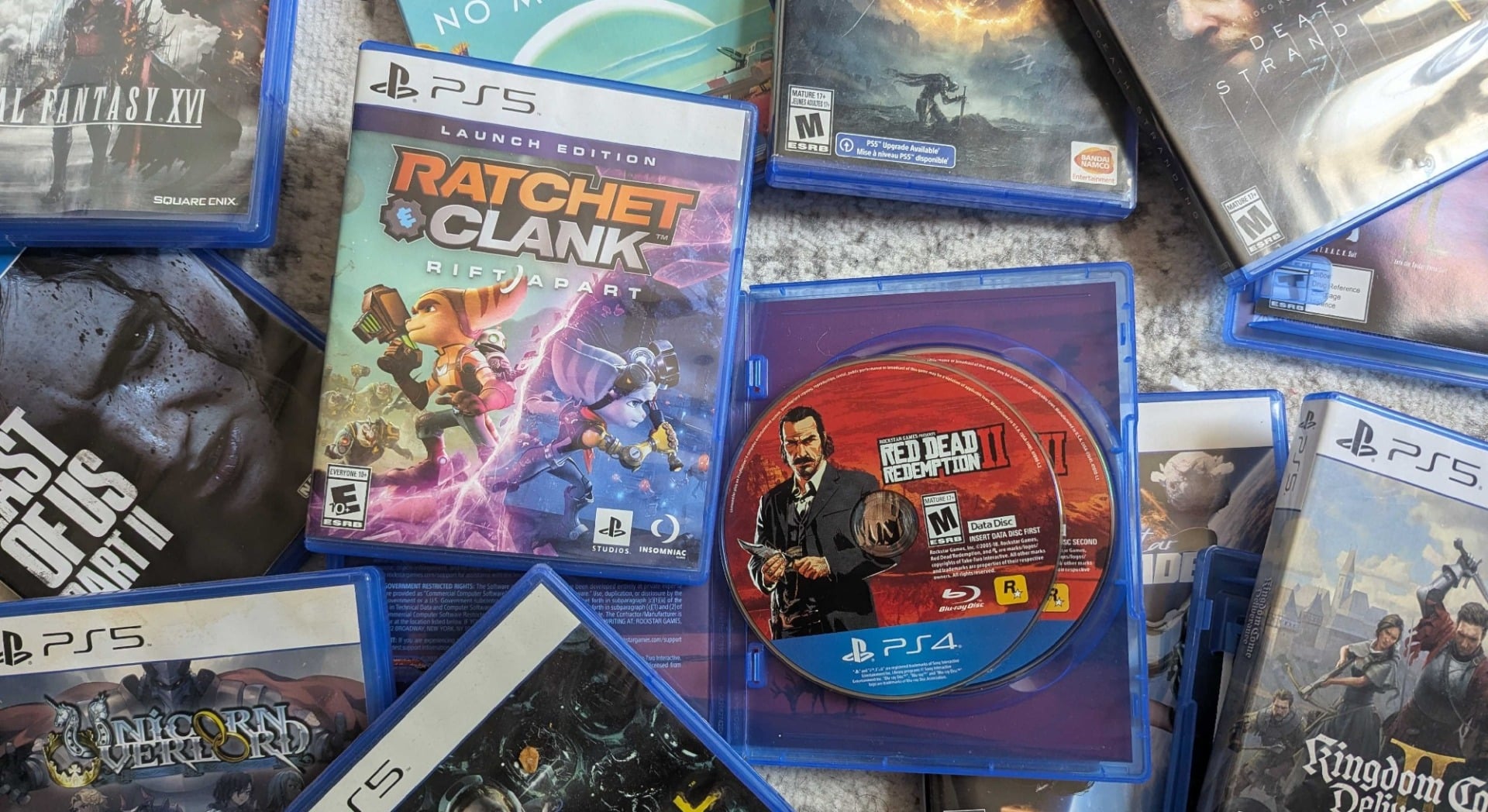 PlayStation game discs and boxes sit on a floor.
