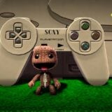 Sack Boy stands in front of a PlayStation console.