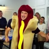 A man wears a hot dog costume.